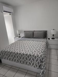 圣胡安San Juan Apartments的一间白色卧室,配有床和2个床头柜