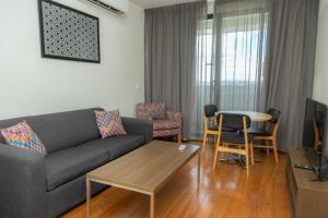丹德农Exodus Dandenong Apartment Hotel的客厅配有沙发和桌椅