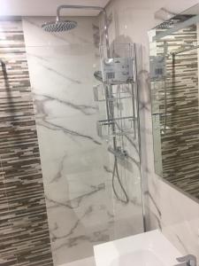 罗尔丹Casa Emperador Penthouse的带淋浴、盥洗盆和镜子的浴室