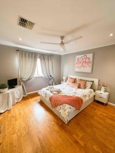 悉尼Frangipani的一间卧室设有一张大床,铺有木地板