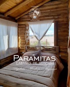 乌斯帕亚塔Paramitas - cabañas y hostel de montaña的小木屋内一间卧室,配有一张床