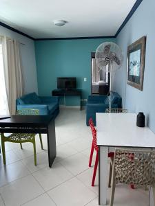 瓜鲁雅Apartamentos Primavera Guarujá的客厅配有沙发和桌子