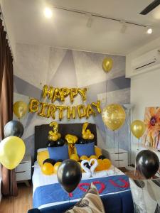 关丹Comfy Imperium Residence Kuantan Studio Seaview的一间卧室,配有一张带气球的床和一个快乐的生日标志