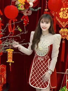 顺化Thuy Duong Boutique Hotel Hue的穿着红色连衣裙的女孩,摆着一张照片