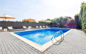 圣韦内里纳Cozy Apartment In Santa Venerina With Outdoor Swimming Pool的庭院内一个带椅子和遮阳伞的游泳池