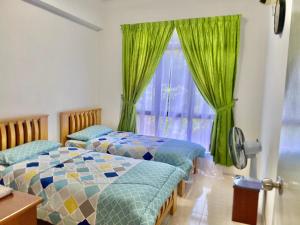 卢穆特Marina Cove, Lumut的配有绿窗帘和窗户的客房内的两张床