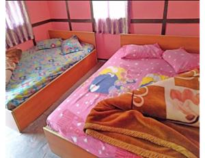 PedongRishi River Cottage, West Bengal的粉红色墙壁客房中的两张单人床