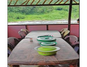 PedongRishi River Cottage, West Bengal的一张木桌,上面有四个绿色的碗