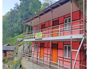 PedongRishi River Cottage, West Bengal的山边的红色和橙色建筑