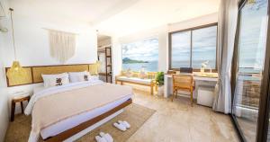 涛岛The AVA Resort Koh Tao的一间卧室配有一张床、一张书桌和一个窗户。