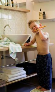 罗伊特丹宁霍夫酒店的一个小男孩在浴室刷牙