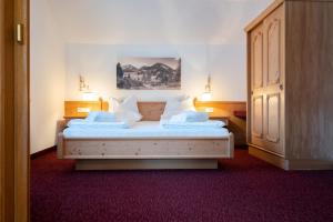 辛特湖DAS Hintersee的一间卧室配有带白色床单和枕头的床。