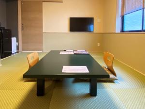 登别花钟亭花屋日式旅馆的一间会议室,配有绿色桌子和两把椅子