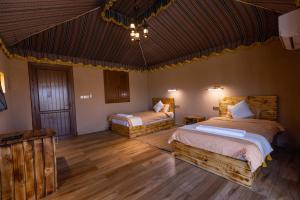 Dār SawdāʼJebel Shams Resort منتجع جبل شمس的铺有木地板的客房内的两张床