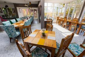 Dār SawdāʼJebel Shams Resort منتجع جبل شمس的餐厅设有木桌、椅子和窗户。