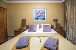 巴蒂泽巴特薇拉酒店的一间卧室配有一张带紫色枕头的大床