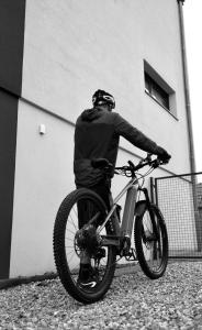 伊斯内姆B&B Chambre Privative Chez L'habitant Sur La Route Des Vins Parking Box vélo的一个人在建筑物前骑着自行车