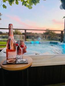 卡迪夫The DeerView Lodge的游泳池畔的桌子上放一瓶葡萄酒和玻璃杯