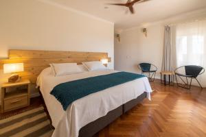塞尔帕Quinta Marugo Retreats的一间卧室配有一张大床和木制床头板