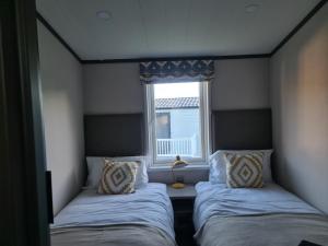 马根波思Mawgan Pads Lazy Days Lodge的小型客房 - 带2张床和窗户