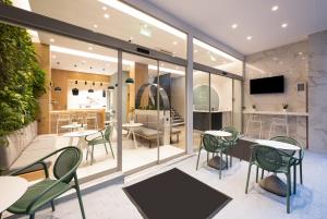 雅典Enattica Suites的一间设有绿色椅子和桌子的餐厅