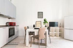 米兰La casa sull'albero City Life的一间厨房,里面配有白色的桌子和椅子