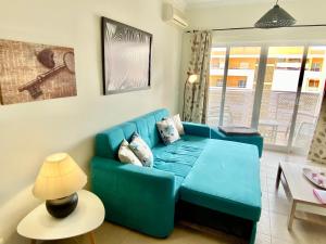 波尔蒂芒Apartamento T1 Flamingo - Portimão - 1,5 km da Praia的客厅配有蓝色的沙发和桌子