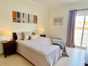 波尔蒂芒Apartamento T1 Flamingo - Portimão - 1,5 km da Praia的一间卧室设有一张大床和一个窗户。