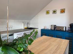 HimmelkronFerienwohnung Fuchs的厨房配有蓝色橱柜和木桌