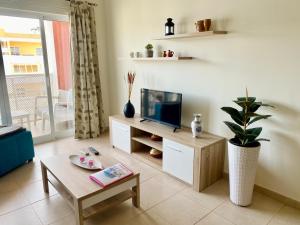 波尔蒂芒Apartamento T1 Flamingo - Portimão - 1,5 km da Praia的客厅配有电视和桌子