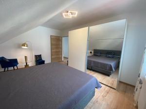 HimmelkronFerienwohnung Fuchs的一间卧室配有一张床、一张沙发和一面镜子