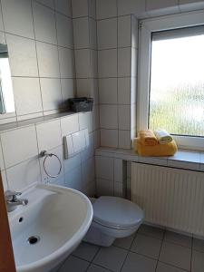 威斯巴登Zimmer Frei 1的一间带水槽和卫生间的浴室以及窗户。