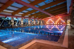 谢尼察Hotel Borovi Forest Resort & Spa的大楼内带灯的大型游泳池