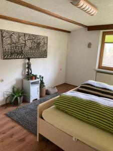 埃尔瓦尔德Ferienhaus Wieswald的卧室配有一张床,墙上挂有绘画作品