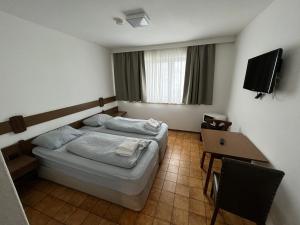 赫尔兴F Hotel的一间卧室配有一张床、一张桌子和一台电视