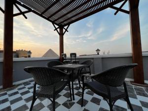 开罗Pyramids Gate Hotel的屋顶上的桌椅,享有金字塔的景色