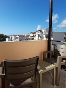 纳弗帕克托斯Ξενοδοχείο Αφροδίτη- Hotel Aphrodite的阳台配有两把椅子和屋顶长凳