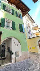 阿科La Casa di Giò的绿色的白色建筑,上面有绿色的百叶窗