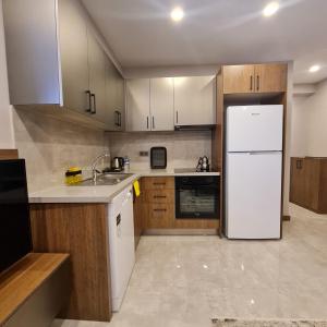 安塔利亚BİSUİTES的厨房配有白色冰箱和木制橱柜。