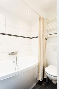 卡罗维发利Apartmá Zeyer 1887的白色的浴室设有浴缸和卫生间。