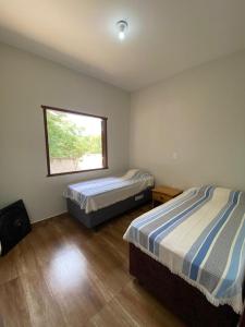 西波山Casa Jatobá da Serra的一间卧室设有两张床和窗户。
