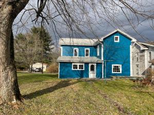 SmicksburgCozy, historic 5-bedroom home in Amish country的一座有树的院子中的蓝色房子