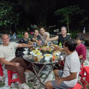 昆岛Garden House Côn Đảo的一群坐在桌子旁吃食物的人