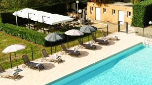 奥内莱沙托Château de Fontanges的一组椅子和遮阳伞,位于游泳池旁