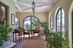斯泰伦博斯Deux Frères Wine Estate & Luxury Villas的客厅配有桌椅和窗户。