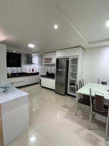 戈亚斯州上帕莱索Cantinho Almeida的一间白色的大厨房,配有桌子和冰箱