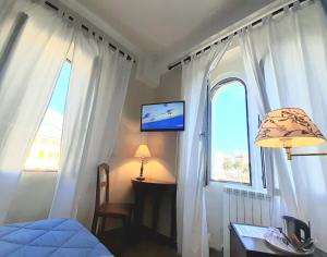 热那亚米拉马雷城堡酒店的一间卧室设有一张床和一个带电视的窗户。