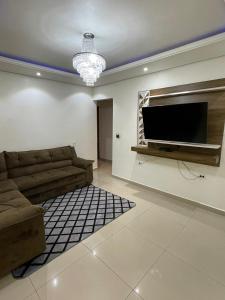 戈亚斯州上帕莱索Cantinho Almeida的带沙发和平面电视的客厅