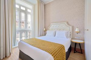 马拉加Tandem Soho Suites的酒店客房设有床和窗户。