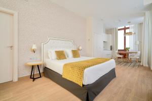 马拉加Tandem Soho Suites的酒店客房设有一张大床和一张桌子。